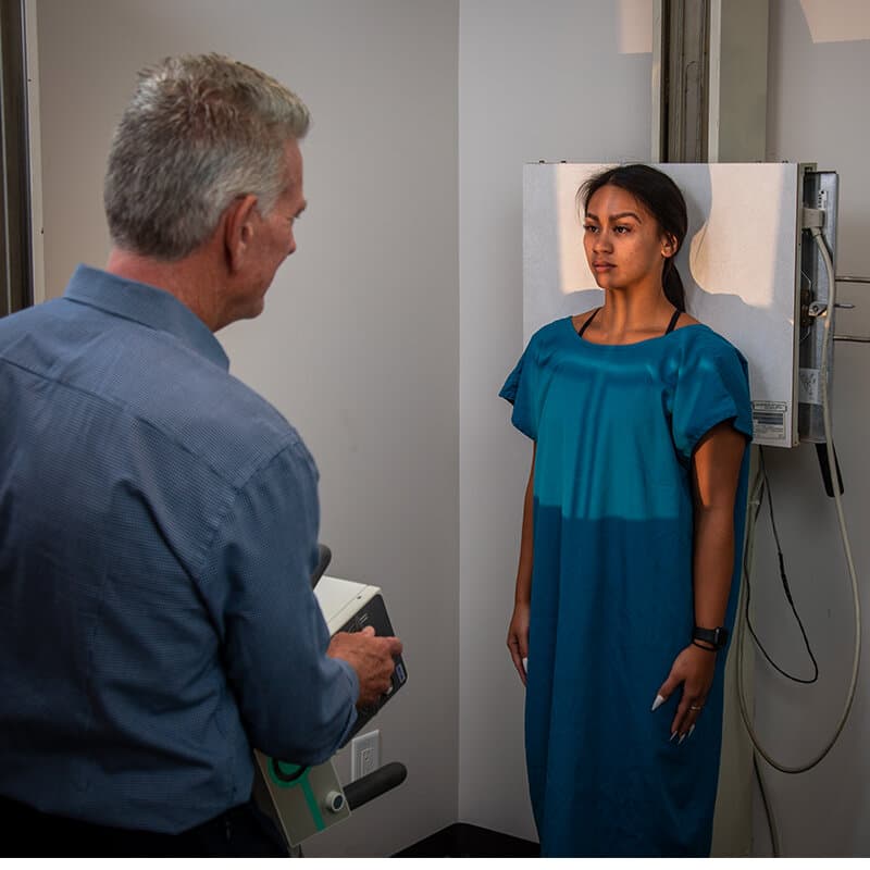 Dr. Foudy performing a standing posture assessment with a patient